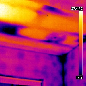 Missing insulation in this bathroom ceiling, and evidence of thermal bridging through the walls. We can also see that the insulation around the back of the light has been pushed aside during the fitting process and therefore energy will escape and be lost through here. This room was incredibly cold because of the missing insulation in the ceiling which can be seen (the dark patches) in this picture. 